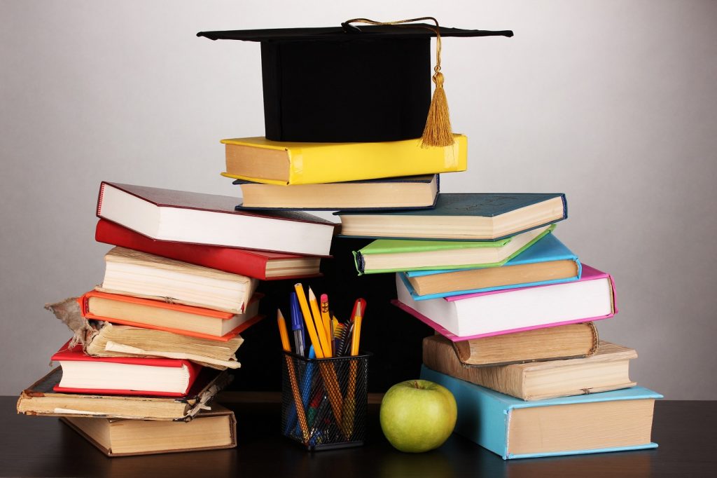 Books and magister cap against school board