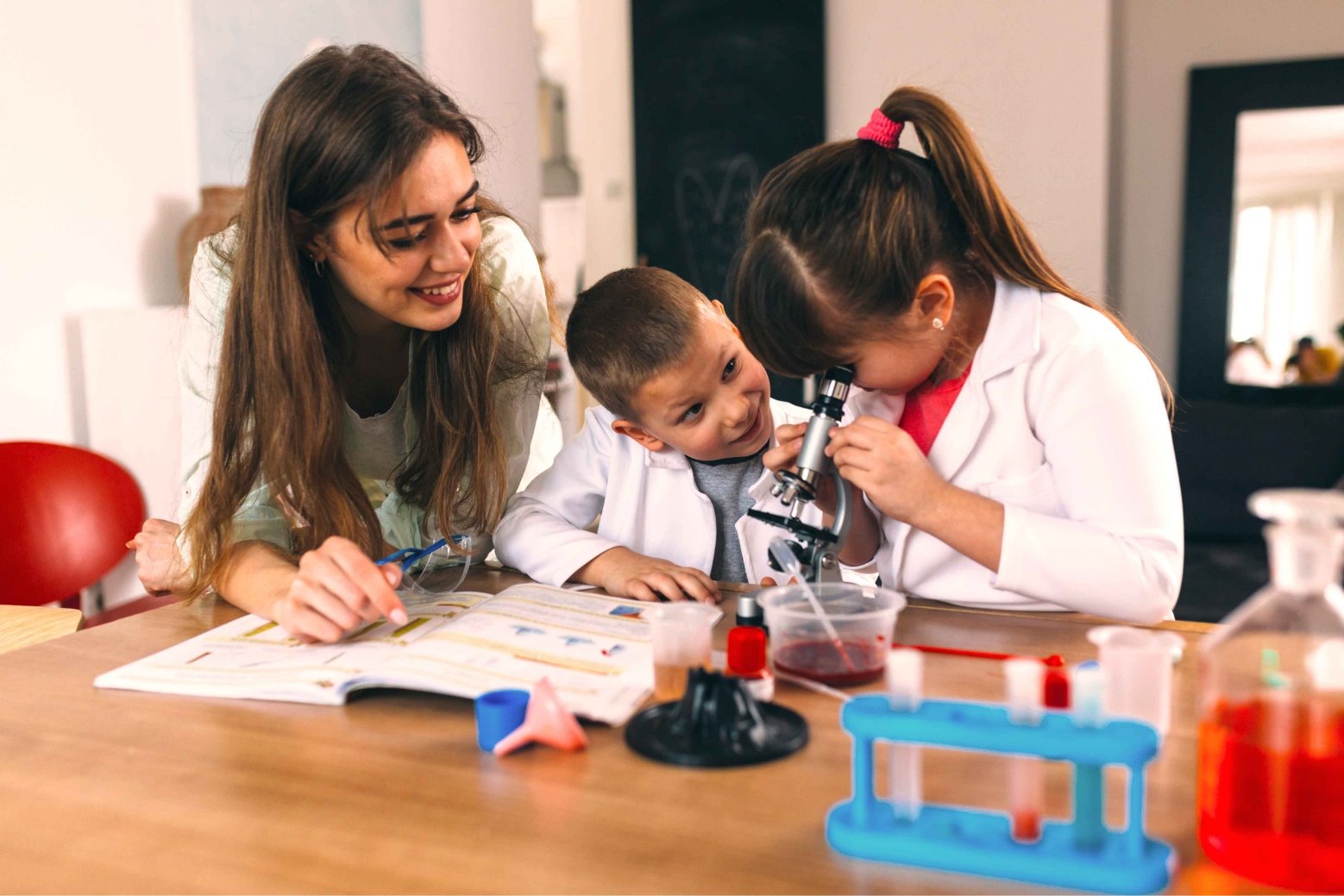 mother and two children using a microscope in a home school science class