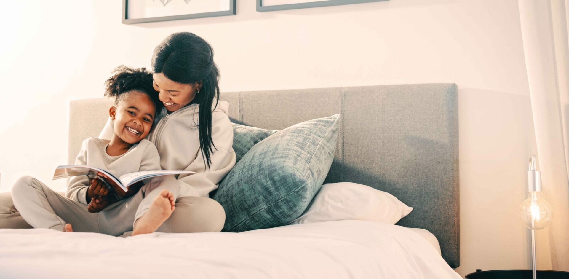 mother and her child reading at home in bed