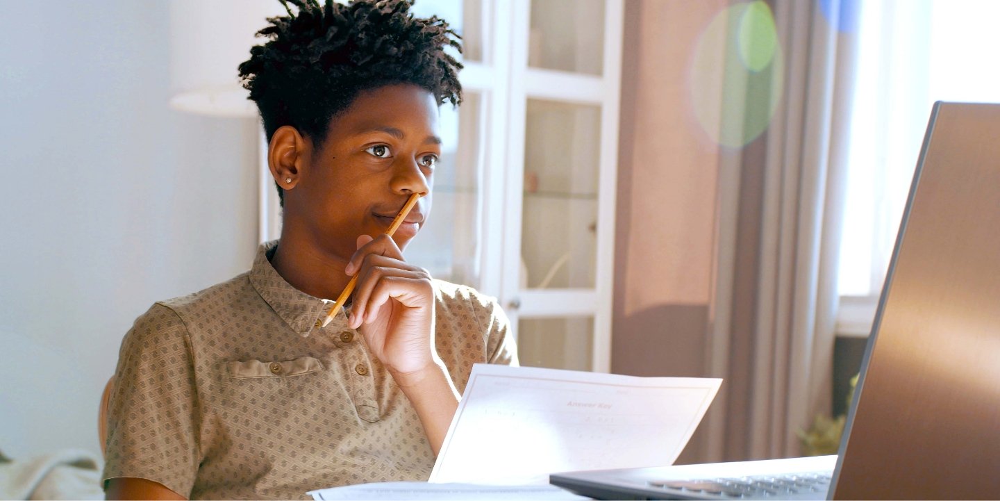 male student thinking about schoolwork sitting at a desk