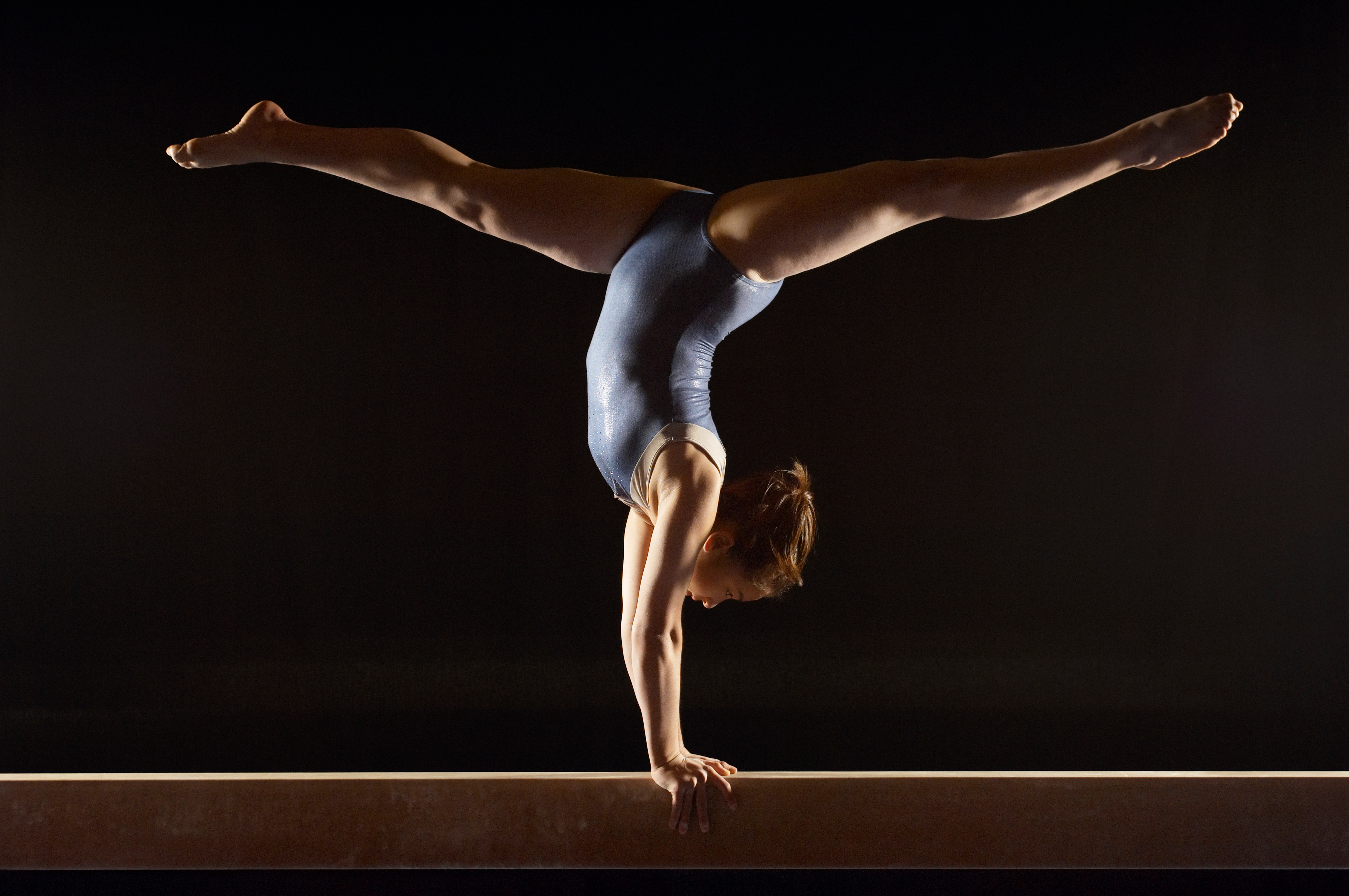 Gymnast Doing Split Handstand on Balance Beam