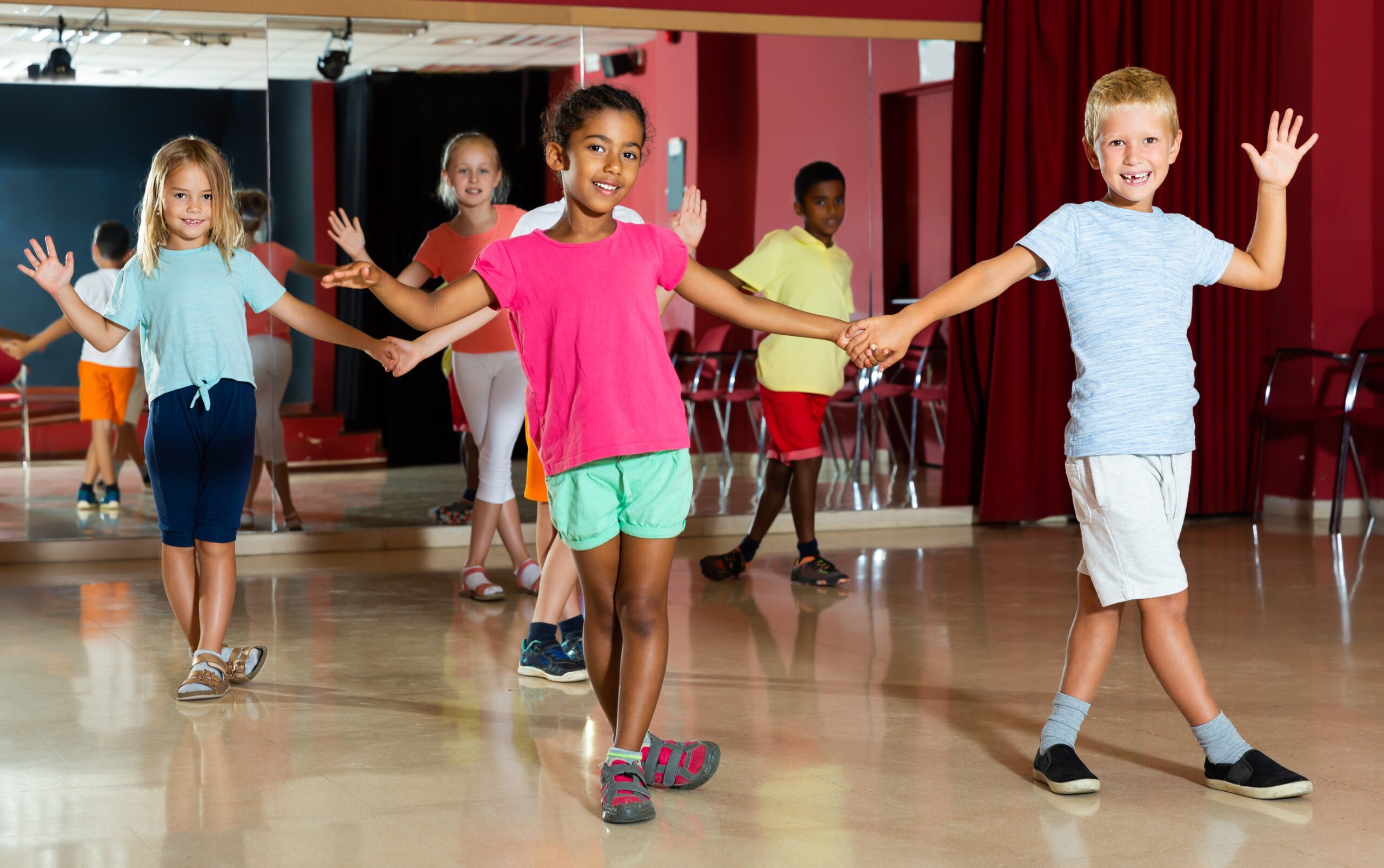 Friendly children trying dancing partner dance in modern studio