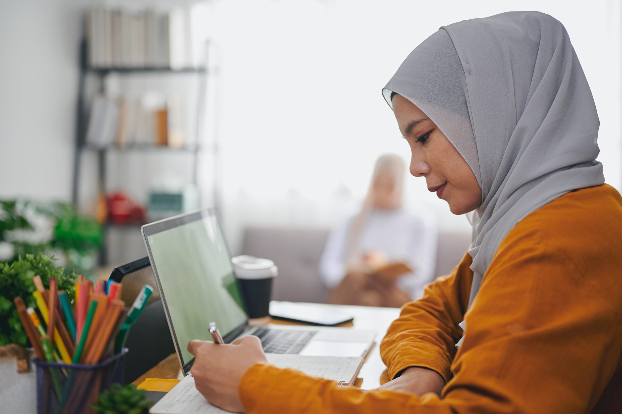 Islamic woman wearing hijab headscarf studying online with laptop