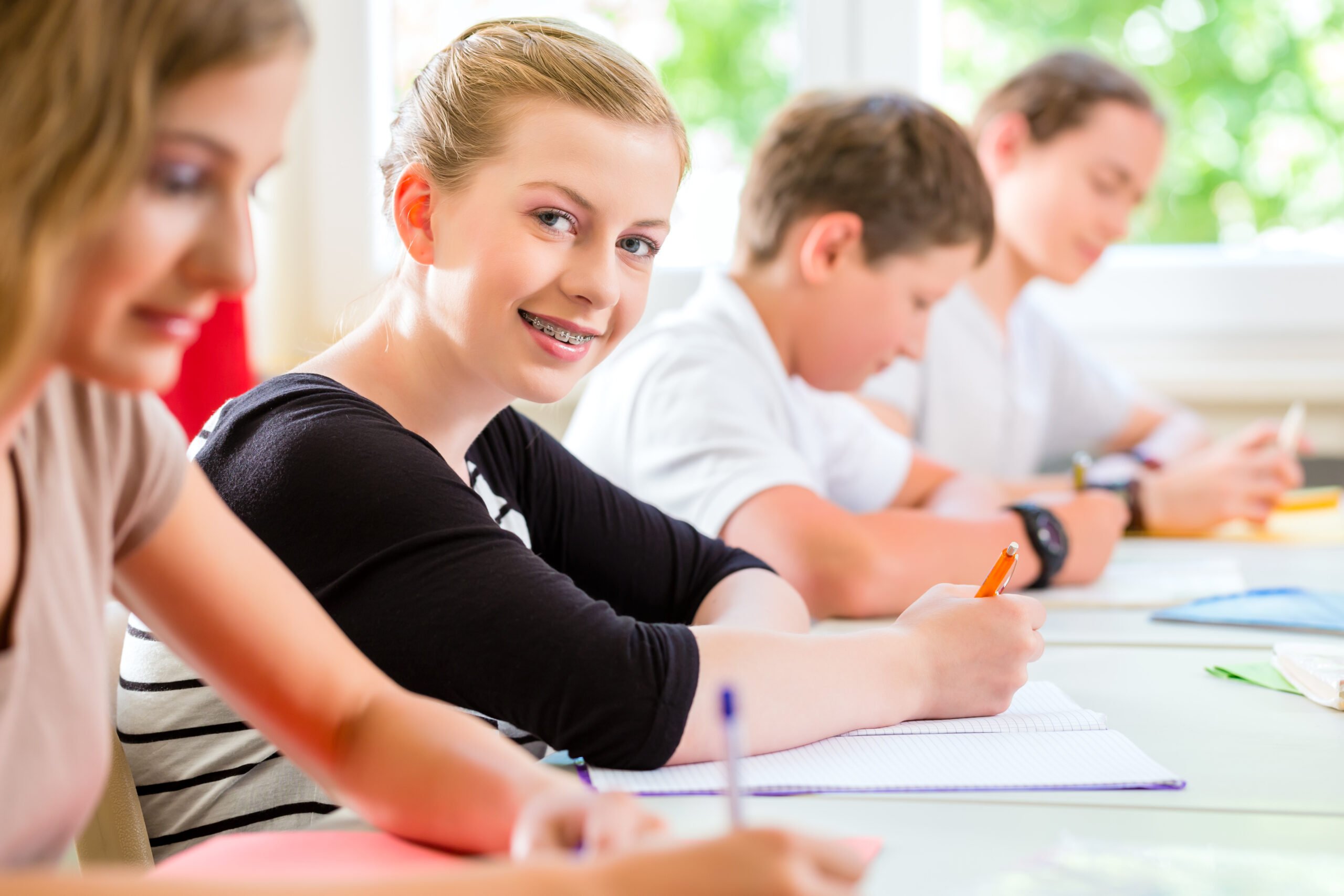 Students or pupils of school class writing an exam test in classroom concentrating on their work