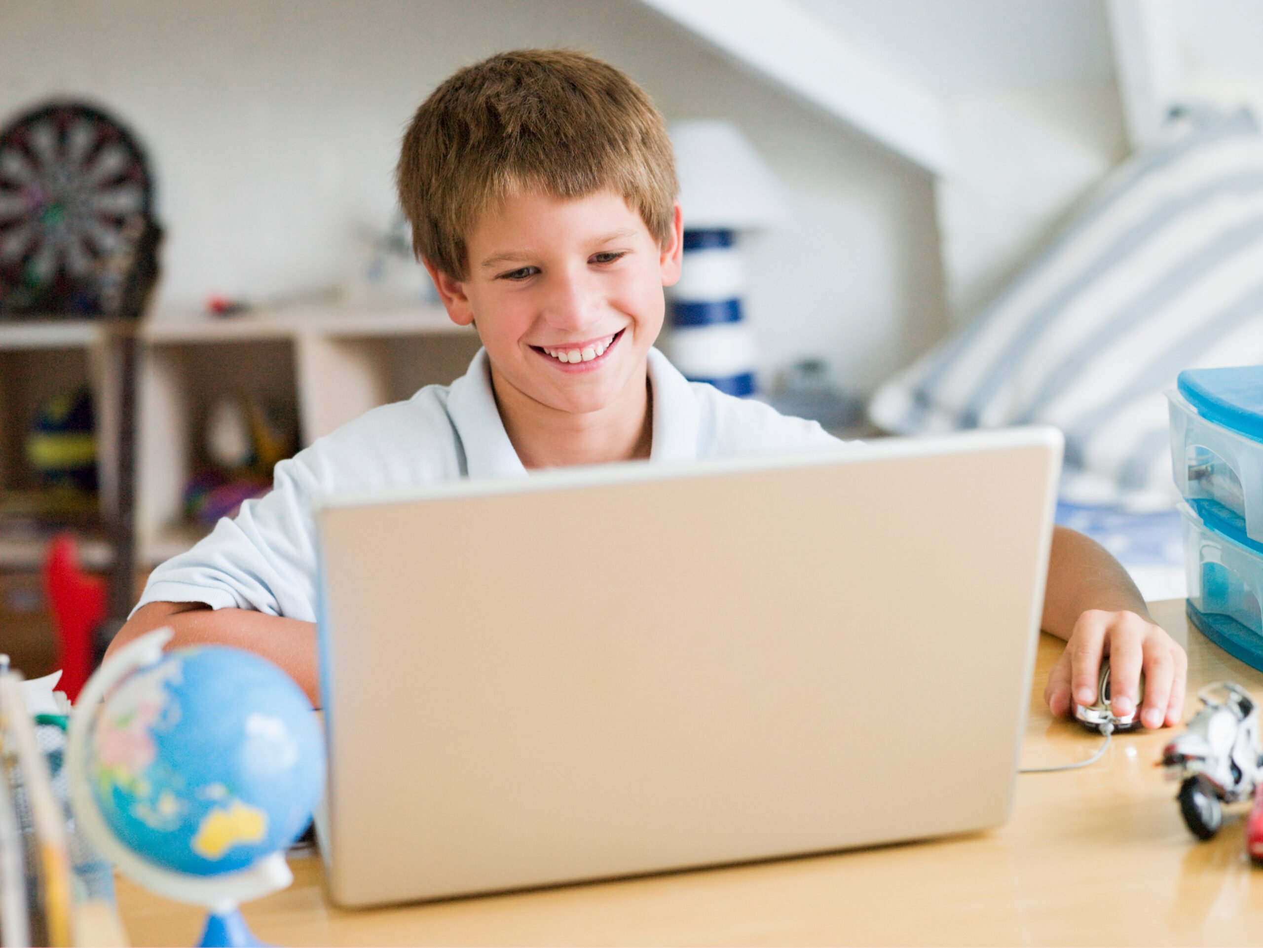 smiling boy using a laptop for schoolwork
