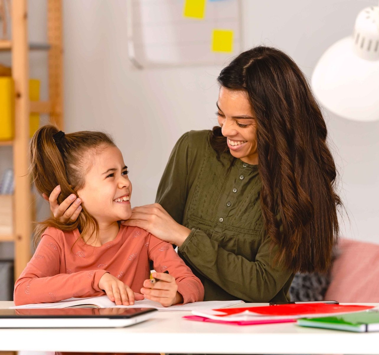 Mom helping girl do schoolwork