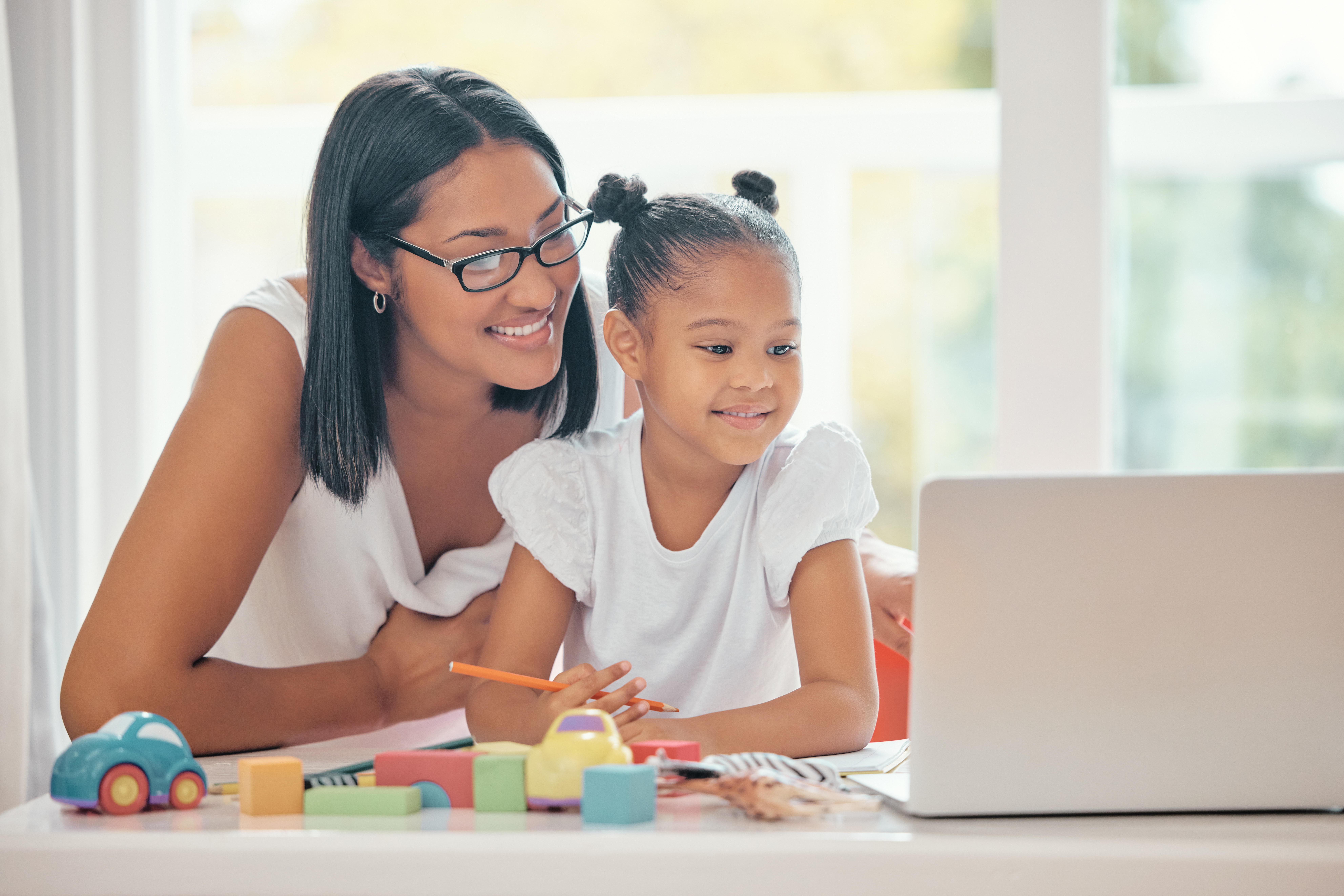 Mother laptop, teaching and learning girl with homework in the room. Mom and kid smile with internet to homeschool her young daughter to help with math, for a happy family on a child education app.
