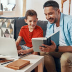 Dad helping son with a school book